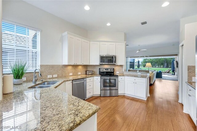 8621 Gleneagle Way, Naples, FL 34120 - kitchen with appliances with stainless steel finishes, a peninsula, open floor plan, tasteful backsplash, and recessed lighting