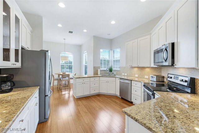 8621 Gleneagle Way, Naples, FL 34120 - kitchen with stainless steel appliances, decorative backsplash, white cabinetry, light stone countertops, and recessed lighting