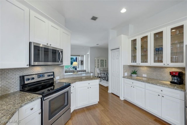 8621 Gleneagle Way, Naples, FL 34120 - kitchen with appliances with stainless steel finishes, tasteful backsplash, white cabinets, glass insert cabinets, and recessed lighting