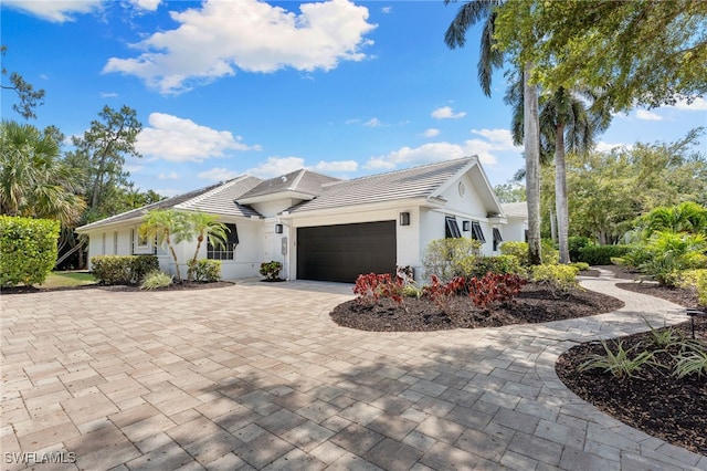 2274 Hawksridge Dr, Naples, FL 34105 - ranch-style home with a garage, driveway, a tiled roof, and stucco siding