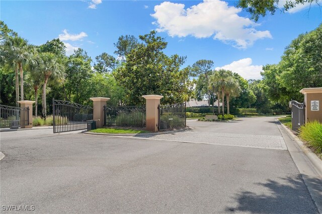 2274 Hawksridge Dr, Naples, FL 34105 - view of asphalt street with a gate, a gated entry, and curbs