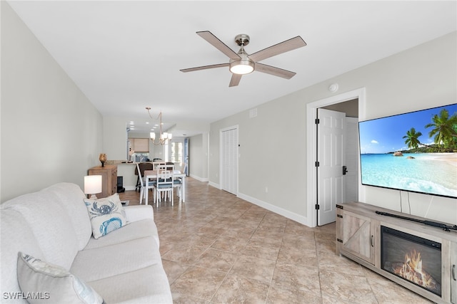 919 Huron Ct Unit B203, Marco Island, FL 34145 - living room with a ceiling fan, a chandelier, and a glass covered fireplace