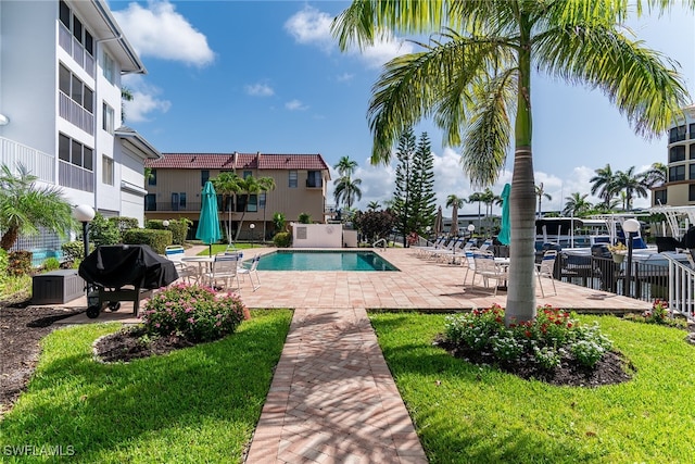 919 Huron Ct Unit B203, Marco Island, FL 34145 - community pool featuring a grill, a patio area, and a yard