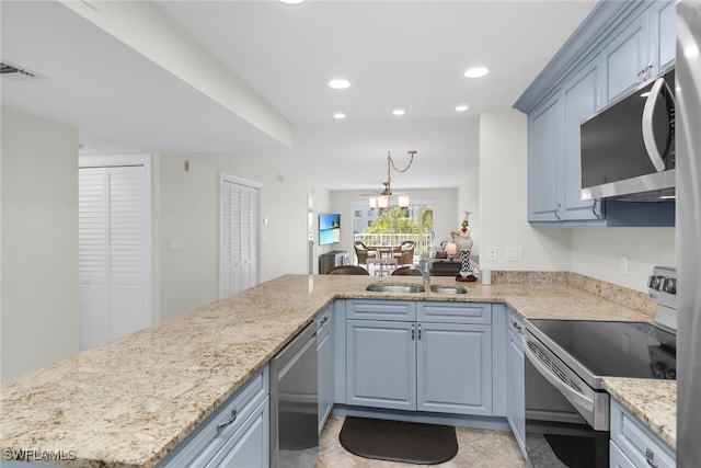 919 Huron Ct Unit B203, Marco Island, FL 34145 - kitchen with stainless steel appliances, a peninsula, recessed lighting, light stone countertops, and decorative light fixtures