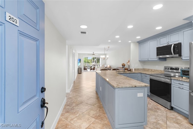 919 Huron Ct Unit B203, Marco Island, FL 34145 - kitchen featuring stainless steel appliances, a peninsula, recessed lighting, light tile patterned floors, and light stone counters