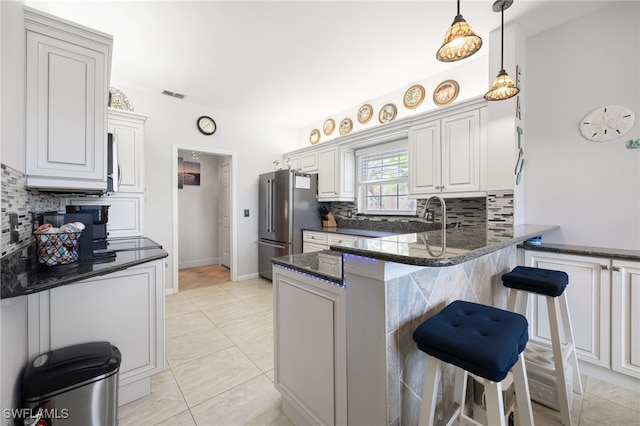 15050 Lakeside View Dr Unit 1001, Fort Myers, FL 33919 - kitchen featuring freestanding refrigerator, a peninsula, backsplash, and a kitchen bar