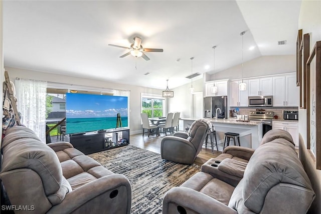 2806 22nd St W, Lehigh Acres, FL 33971 - living room featuring light wood finished floors, vaulted ceiling, and a ceiling fan