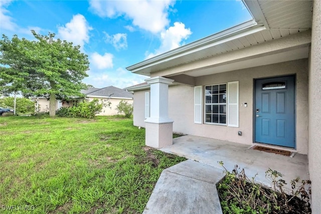 2806 22nd St W, Lehigh Acres, FL 33971 - property entrance featuring a lawn and stucco siding
