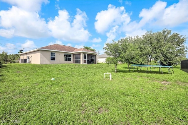 2806 22nd St W, Lehigh Acres, FL 33971 - view of grassy yard with a trampoline and a sunroom
