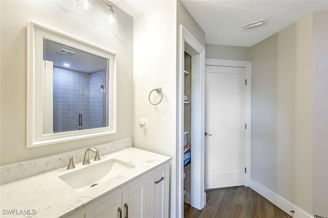 2806 22nd St W, Lehigh Acres, FL 33971 - bathroom featuring vanity, wood finished floors, a shower with door, and a closet