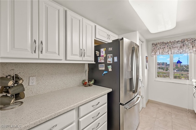 7400 Estero Blvd Unit 629, Fort Myers Beach, FL 33931 - kitchen featuring stainless steel fridge with ice dispenser, white cabinetry, light tile patterned flooring, light stone countertops, and backsplash
