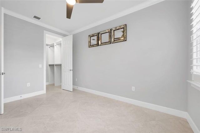 7690 Jacaranda Ln, Naples, FL 34114 - unfurnished bedroom featuring ceiling fan, a spacious closet, a closet, crown molding, and light tile patterned floors