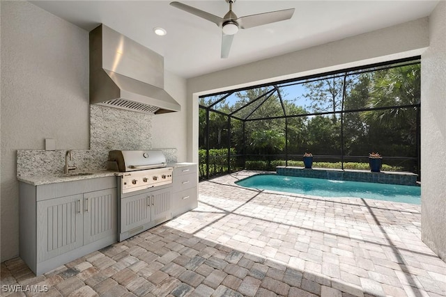 7690 Jacaranda Ln, Naples, FL 34114 - swimming pool with an outdoor kitchen, a patio area, glass enclosure, and a ceiling fan