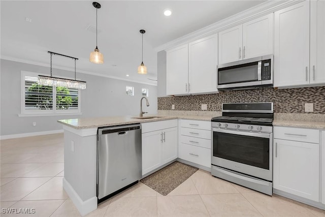 7690 Jacaranda Ln, Naples, FL 34114 - kitchen featuring appliances with stainless steel finishes, crown molding, decorative backsplash, white cabinets, and a peninsula