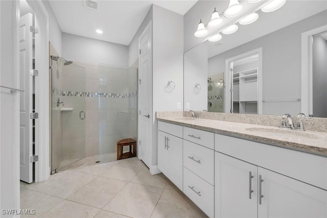 7690 Jacaranda Ln, Naples, FL 34114 - full bathroom with a stall shower, double vanity, a walk in closet, tile patterned flooring, and recessed lighting