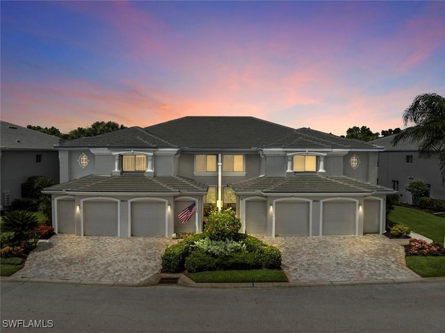 8421 Southbridge Dr Unit 4, Estero, FL 33967 - view of front of house with decorative driveway, a garage, a tiled roof, and stucco siding
