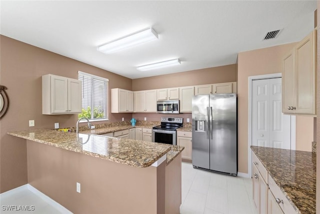 8421 Southbridge Dr Unit 4, Estero, FL 33967 - kitchen featuring appliances with stainless steel finishes, a peninsula, light stone counters, and white cabinets