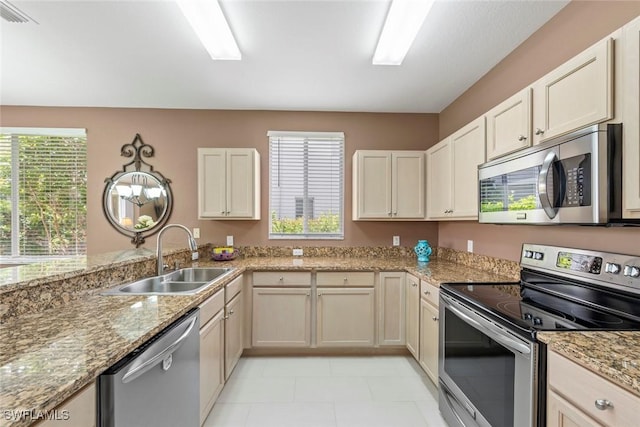 8421 Southbridge Dr Unit 4, Estero, FL 33967 - kitchen with stainless steel appliances, light stone countertops, light tile patterned flooring, and a peninsula
