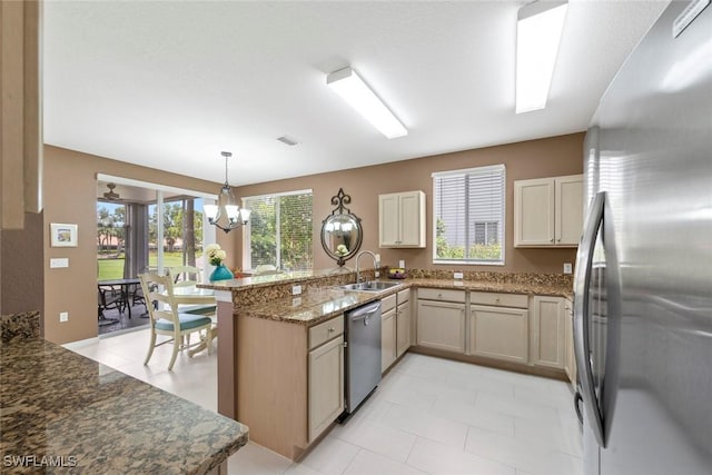 8421 Southbridge Dr Unit 4, Estero, FL 33967 - kitchen featuring appliances with stainless steel finishes, a peninsula, light stone countertops, a chandelier, and pendant lighting