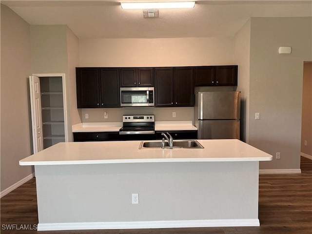 19474 Strathcona Ave, Port Charlotte, FL 33954 - kitchen featuring stainless steel appliances, dark wood-style floors, light countertops, and an island with sink