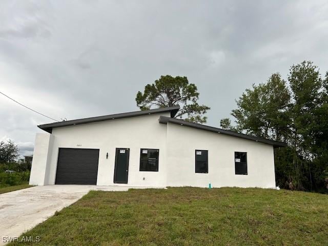 2603 3rd St SW, Lehigh Acres, FL 33976 - view of property exterior featuring stucco siding, a garage, concrete driveway, and a lawn