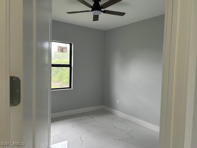 2603 3rd St SW, Lehigh Acres, FL 33976 - unfurnished room with marble finish floors and a ceiling fan