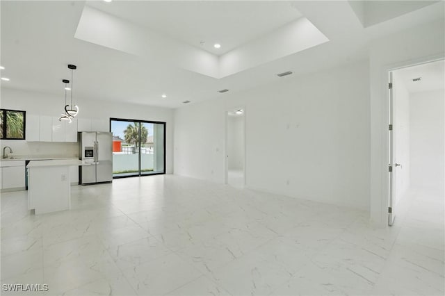 472 Rajah St, Lehigh Acres, FL 33974 - unfurnished living room with a tray ceiling, recessed lighting, and light marble finish floors