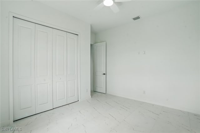 472 Rajah St, Lehigh Acres, FL 33974 - unfurnished bedroom featuring marble look tiles, a closet, and a ceiling fan