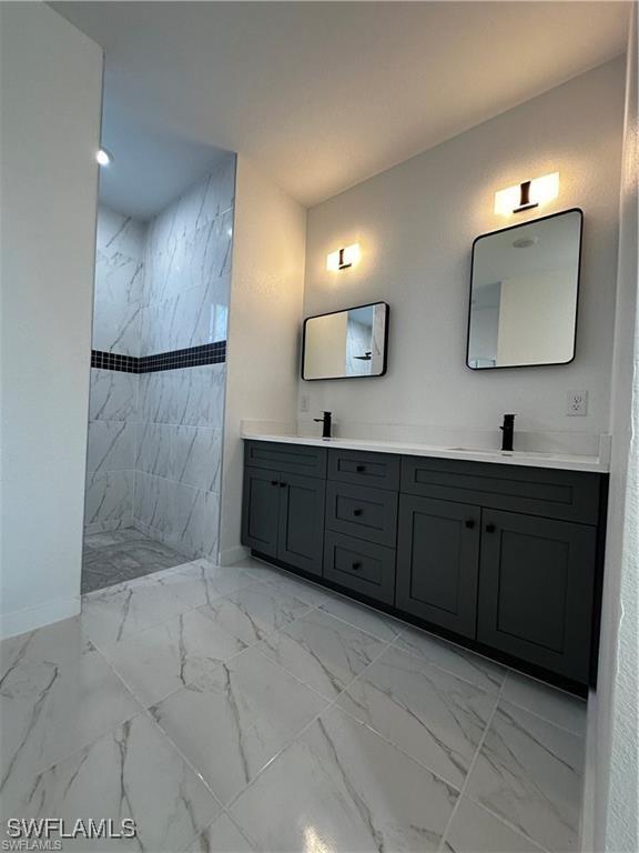 394 Palora Ave, Lehigh Acres, FL 33974 - full bath with double vanity, marble finish floors, and a walk in shower