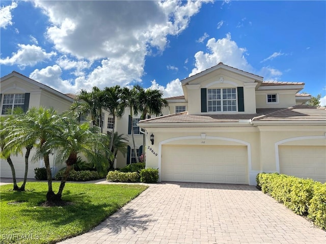 28649 San Lucas Ln Unit 102, Bonita Springs, FL 34135 - view of front facade featuring a garage, decorative driveway, a tile roof, and stucco siding
