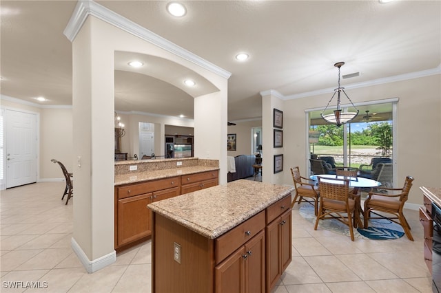 28649 San Lucas Ln Unit 102, Bonita Springs, FL 34135 - kitchen with light tile patterned floors, brown cabinetry, ornamental molding, light stone counters, and a center island