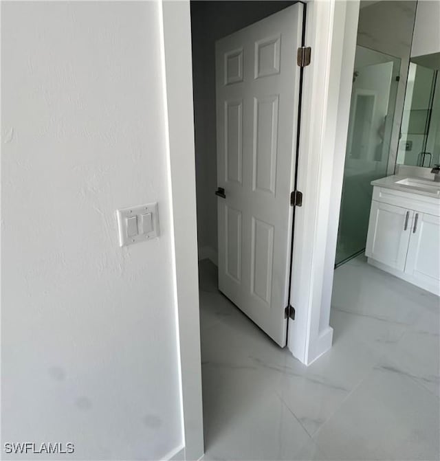 821 Bell Blvd S, Lehigh Acres, FL 33974 - corridor featuring light marble finish flooring and a sink