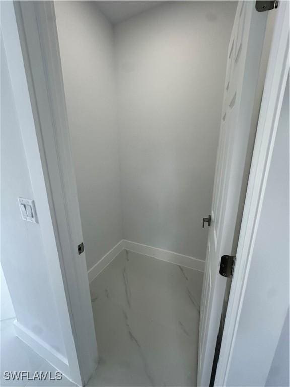 821 Bell Blvd S, Lehigh Acres, FL 33974 - laundry area with marble look tile flooring and baseboards
