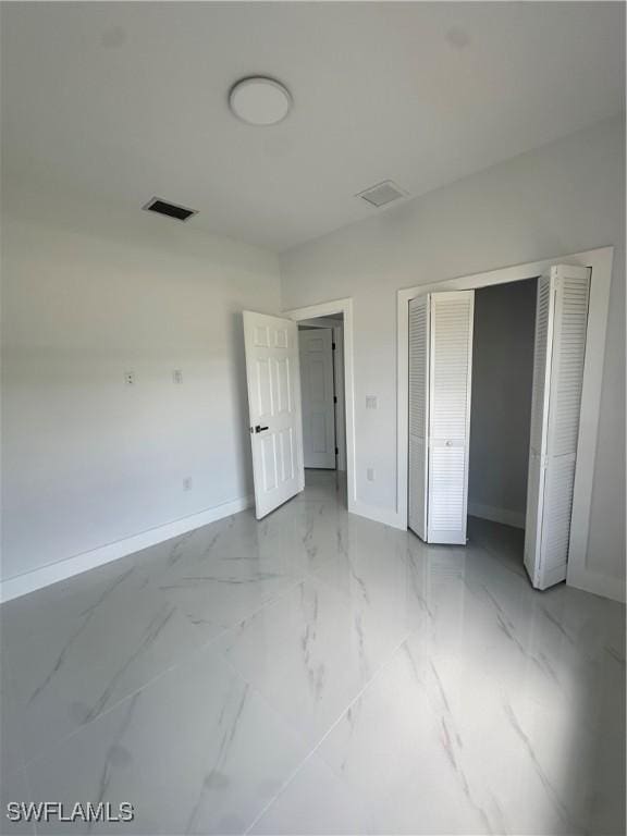 821 Bell Blvd S, Lehigh Acres, FL 33974 - unfurnished bedroom with light marble finish flooring and a closet