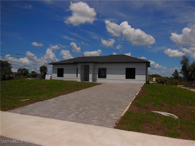 821 Bell Blvd S, Lehigh Acres, FL 33974 - contemporary home with a front yard, decorative driveway, and stucco siding