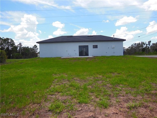 821 Bell Blvd S, Lehigh Acres, FL 33974 - rear view of house with a yard and stucco siding