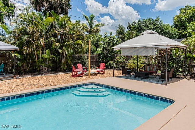 1413 Davis Dr, Fort Myers, FL 33919 - view of swimming pool featuring a gazebo, a patio area, an outdoor living space with a fire pit, and a fenced backyard