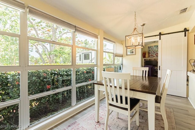 1413 Davis Dr, Fort Myers, FL 33919 - dining area with a barn door, light wood-type flooring, and a chandelier