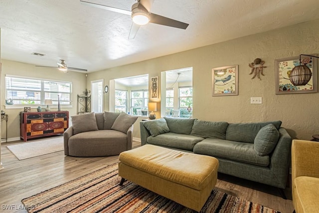 1413 Davis Dr, Fort Myers, FL 33919 - living room featuring a ceiling fan, a textured wall, wood finished floors, and plenty of natural light
