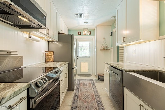 1413 Davis Dr, Fort Myers, FL 33919 - kitchen with appliances with stainless steel finishes, light tile patterned floors, light stone counters, white cabinetry, and a textured ceiling