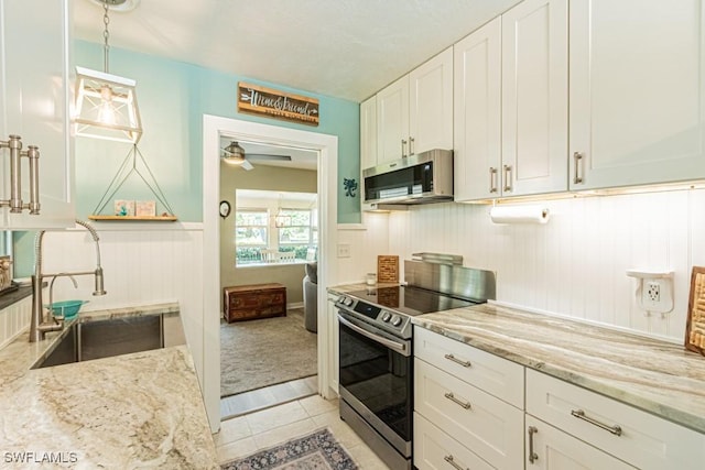 1413 Davis Dr, Fort Myers, FL 33919 - kitchen with stainless steel appliances, light stone countertops, white cabinetry, a ceiling fan, and light tile patterned floors