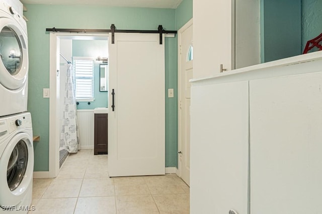 1413 Davis Dr, Fort Myers, FL 33919 - laundry area featuring stacked washer and clothes dryer, light tile patterned floors, and a barn door
