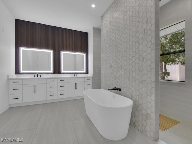 3475 3rd Ave SW, Naples, FL 34117 - full bathroom with a soaking tub, double vanity, an accent wall, tile patterned flooring, and recessed lighting