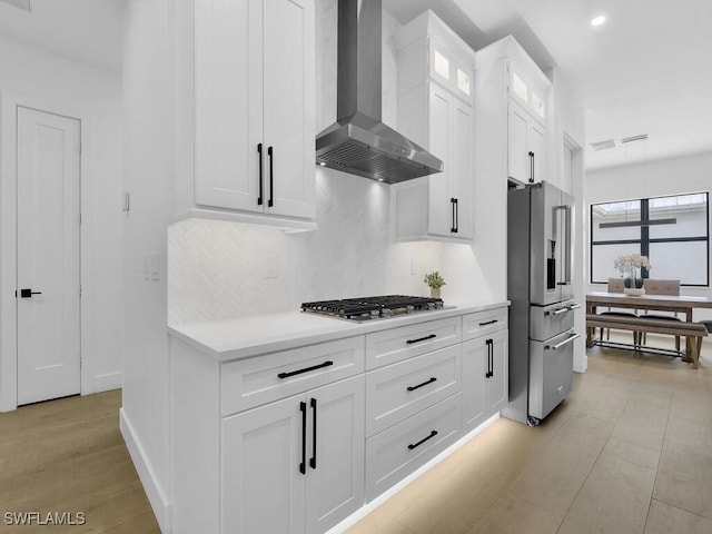 3475 3rd Ave SW, Naples, FL 34117 - kitchen with wall chimney exhaust hood, stainless steel appliances, backsplash, light countertops, and white cabinetry