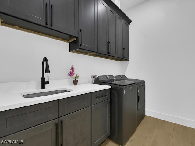 3475 3rd Ave SW, Naples, FL 34117 - washroom with cabinet space, separate washer and dryer, and light wood-style flooring
