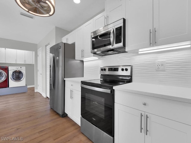 3475 3rd Ave SW, Naples, FL 34117 - kitchen featuring stainless steel appliances, separate washer and dryer, light countertops, and white cabinets