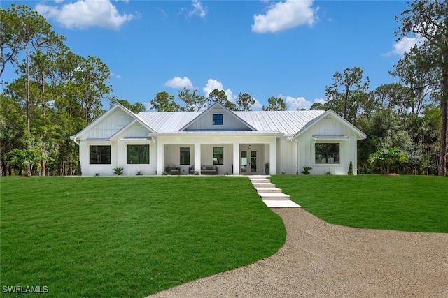 3475 3rd Ave SW, Naples, FL 34117 - modern farmhouse featuring board and batten siding, a front yard, a metal roof, and a standing seam roof