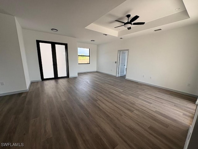 1024 Halby Ave S, Lehigh Acres, FL 33974 - empty room with a tray ceiling, dark wood-style flooring, and ceiling fan