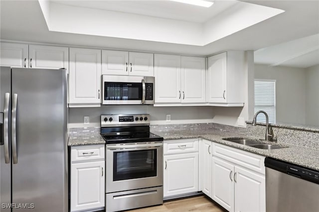 740 SW 5th St, Cape Coral, FL 33991 - kitchen featuring stainless steel appliances, white cabinetry, light stone countertops, and light wood finished floors