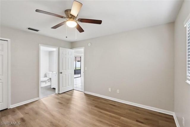 740 SW 5th St, Cape Coral, FL 33991 - unfurnished bedroom with wood finished floors, ensuite bath, multiple windows, and a ceiling fan